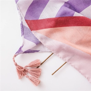 Detail of colorful striped cotton linen shawl with soft fringe tassels and fabric texture
