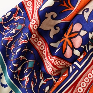Close-up of ethnic cotton linen scarf with vibrant totem patterns and silk texture
