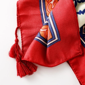 Close-up of red cotton linen scarf featuring ethnic geometric patterns and silk fringes
