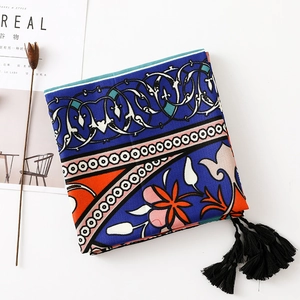 Close-up of ethnic cotton linen scarf featuring blue totem prints and long black tassels