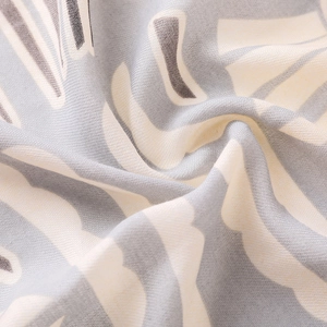 Gros plan d'une écharpe en lin imprimé floral géométrique gris et beige texture douce