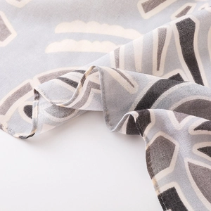 Gros plan sur le motif géométrique et la texture douce d'un foulard en coton et lin