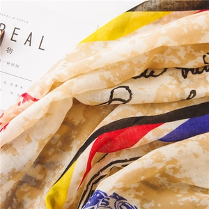 Detail of cotton linen scarf with abstract yellow and blue stripes and letter prints