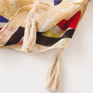 Detailed macro view of colorful geometric patterns and creamy white fringe on a cotton scarf