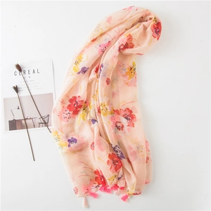 Detail of pink floral scarf with elegant tassels and artistic print on linen cotton fabric