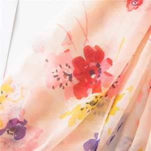 Macro shot of lightweight sheer fabric with romantic watercolor floral patterns in soft tones
