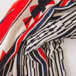 Détail d'un châle en coton et lin avec des motifs géométriques rouge et bleu marine