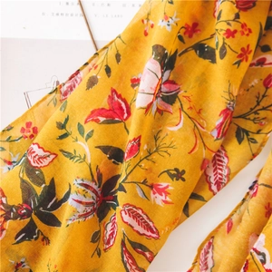 Detailed macro shot of vintage yellow floral cotton linen scarf with red flower prints