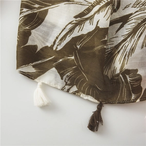 Detail of banana leaf print scarf with elegant fringe tassels and soft breathable fabric