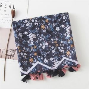 Detailed close-up of floral navy cotton scarf with colorful tassels and soft texture