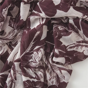 Detail showing tropical banana leaf print on breathable maroon lightweight fabric scarf