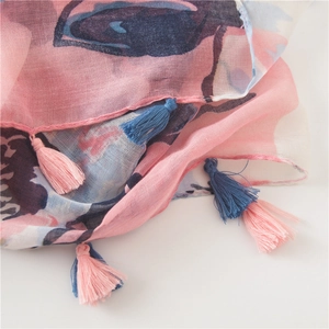 Close-up of pink and blue floral print scarf with fine fringe tassels and soft texture