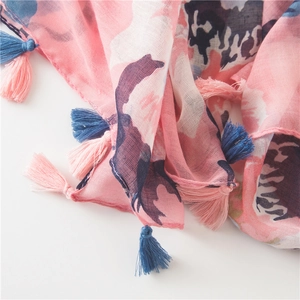 Close-up of lightweight floral scarf showing pink and blue tassels and soft fabric texture