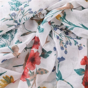 Gros plan d'une écharpe en coton et lin à fleurs montrant la texture et les motifs d'été