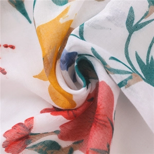 Gros plan sur l'écharpe en coton et lin montrant des fleurs colorées et la texture du tissu