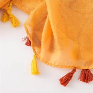 Detailed texture of orange cotton linen shawl featuring bohemian bicolor tassels edges