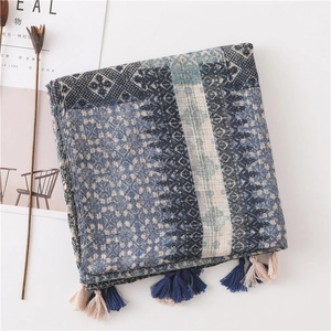 Detail of bohemian geometric knit scarf with bicolor fringe tassels on white background