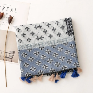 Detail of cotton linen scarf featuring floral and star patterns with fringe tassels