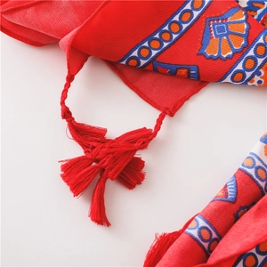 Detailansicht eines roten Bohemian-Strandtuches mit Quasten und geometrischen Drucken