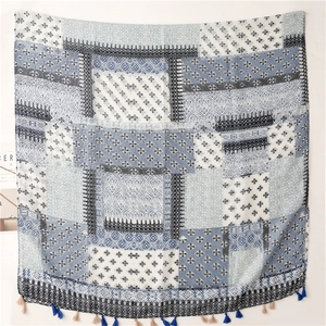 Detail of bohemian plaid cotton scarf with vintage floral patterns and fringe tassels