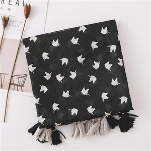 Detail of animal print beach shawl featuring white unicorn motifs and grey fringe tassels