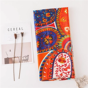 Colorful paisley cotton linen scarf with tassels and magazine for beach travel styling
