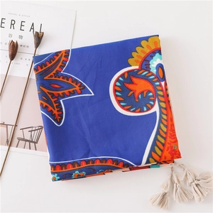Detail of bohemian paisley scarf with white tassels and royal blue cotton fabric