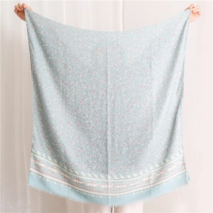 Detail of blue floral cotton scarf with ethnic geometric borders and soft fringe edges