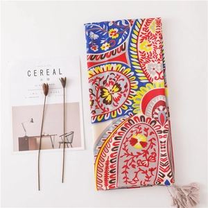 Bohemian paisley print scarf with pink tassels shown on a minimalist white backdrop
