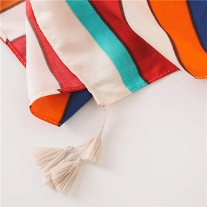 Close-up of colorful striped cotton linen scarf with handmade cream fringe edges