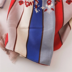 Detailed macro view of bohemian silk scarf with colorful stripes and pink tassel fringe
