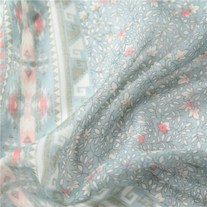 Detailed macro shot of blue floral cotton linen scarf with ethnic geometric borders