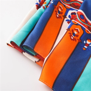 Close-up of bohemian paisley printed fabric with vibrant orange and blue ethnic patterns