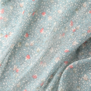 Close-up of blue floral cotton scarf fabric with pink flowers and fine linen texture