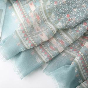 Detailed close-up of light blue floral scarf showing soft fabric texture and fringe edges