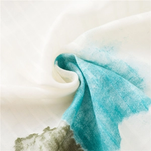 Gros plan sur la texture du foulard montrant l'imprimé aquarelle bleu et la fibre