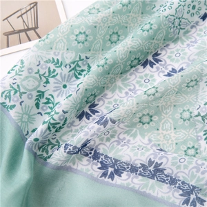 Detailed view of soft linen scarf featuring elegant blue floral print and fringe edges