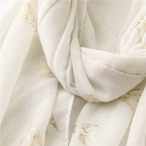 Detailed view of lightweight white cotton-linen scarf with golden swallow foil printing