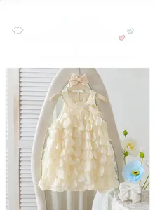 Detailaufnahme des ärmellosen Mädchenkleides mit Blütenblättern und Schleife am Bogenspiegel