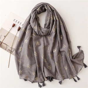 Detail of gray cotton linen scarf with golden swallow pattern and fringe edges