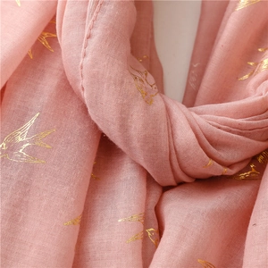 Macro view of gold swallow foil print on pink breathable cotton linen scarf fabric