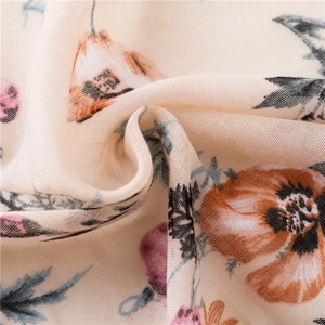 Détail d'une écharpe en coton et lin avec imprimés floraux et texture de tissu doux