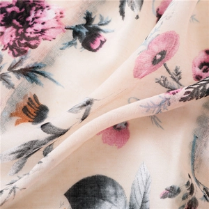 Détail d'une écharpe fleurie en lin montrant des pivoines et une texture tissée