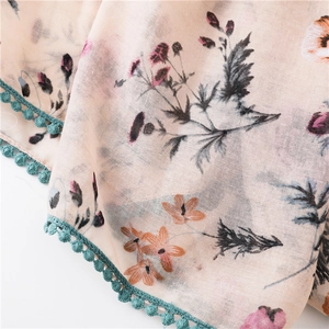 Détail d'une écharpe fleurie avec bordure en crochet bleu et texture délicate
