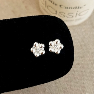 Macro detail of silver flower earrings with marquise zircon petals on black velvet stand