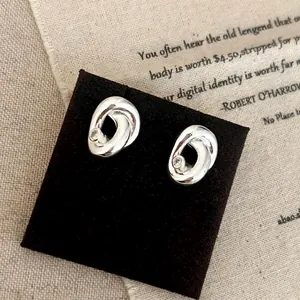 Vue détaillée des boucles d'oreilles torsadées argentées avec un zircon central brillant