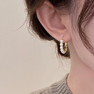 Élégantes boucles d'oreilles créoles dorées en C avec petites perles sur mannequin