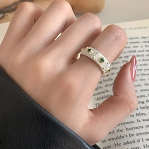 French style silver ring with green stones and starburst engraving on textured band