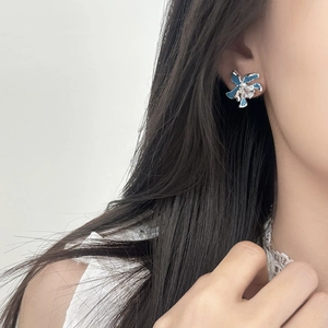 Elegante blaue Emaille-Blumenohrringe mit Zirkonia-Zentrum, am Modell getragen