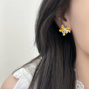 Elegante gelbe Blumenohrstecker mit Zirkon-Stein, getragen von einem weiblichen Model